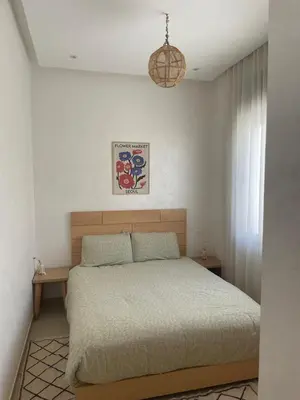 a bedroom with a bed and a chandelier at Beautiful beachfront villa in Dar Bouazza