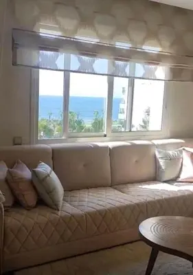 a living room with a couch and a large window at Luxury SeaView Apartment 2 Minutes From Beachfront in Rabat