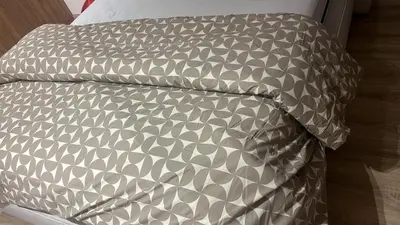 a bed with a gray and white comforter and a pillow at Casablanca Luxe studio in Casablanca
