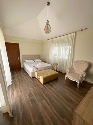 a bedroom with a large bed and a chair at Villa Prestige avec piscine in Tamaris