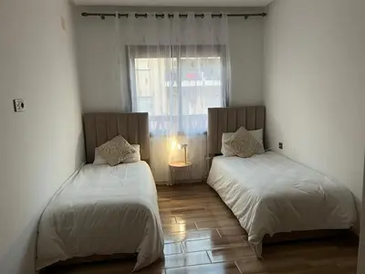 two beds in a room with a window at Modern fully-equipped apartment in a residence in Pont Blondin