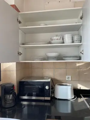 a kitchen with a microwave on a counter with dishes at Beautiful 3 Bedroom in Heart of Hay Riad in Rabat