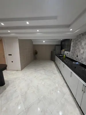 a large kitchen with white cabinets and a large tile floor at Saad's villa in Mohammedia
