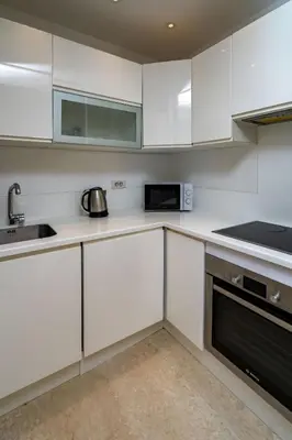 a kitchen with white cabinets and a sink and a microwave at Appartement cosy & chic Triangle d'or in Casablanca
