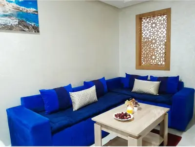 a blue couch in a living room with a table at Studio confortable au centre rabat agdal à côté du stade in Gare de Rabat-Aguedal