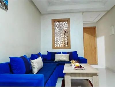 a blue couch in a living room with a table at Studio confortable au centre rabat agdal à côté du stade in Gare de Rabat-Aguedal