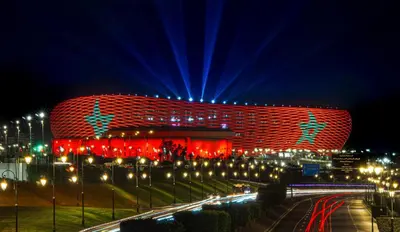 a building lit up with red and blue lights at night at Appartement à 2 min gare Agdal bien situé in Rabat