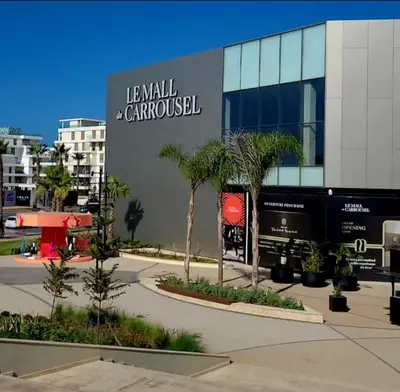a large building with palm trees in front of it at appartement prés de corniche de rabat in Rabat