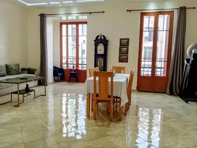 a dining room with a table and a grandfather clock at Casablanca City Center Neoclassic Flat in Casablanca