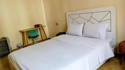 a bedroom with a white bed and a blue chair at Casablanca City Center Neoclassic Flat in Casablanca