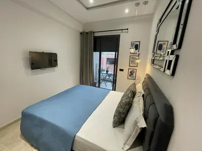 a bedroom with a large bed with a blue blanket at Studio oasis calme et spacieux in Maarif