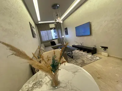 a living room with a table with a vase on it at Studio oasis calme et spacieux in Maarif