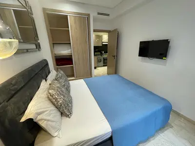 a bedroom with a bed with a couch and a tv at Studio oasis calme et spacieux in Maarif