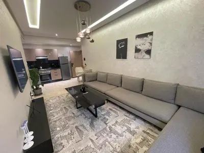 a living room with a couch and a table at Studio oasis calme et spacieux in Maarif