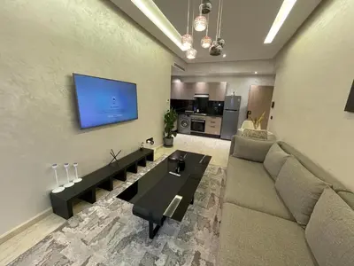 a living room with a couch and a tv on the wall at Studio oasis calme et spacieux in Maarif