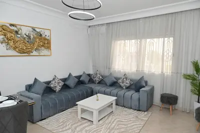 a living room with a blue couch and a table at Modern Luxury Apartment - Ground Floor in Rabat