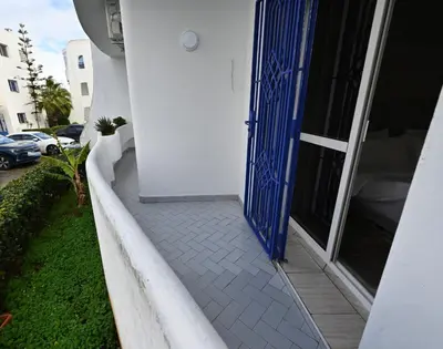 a blue door on a white building with a sidewalk at Modern Luxury Apartment - Ground Floor in Rabat