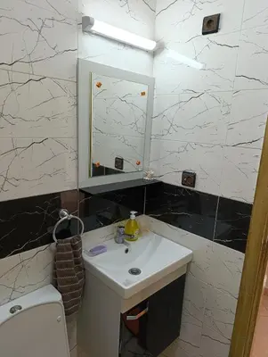 a bathroom with a sink and a mirror and a toilet at Carino Solare ben ordinato in Dar Ben Abdallah Ben Dehbi