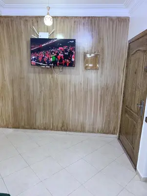 a room with a wooden wall with a tv on it at Carino Solare ben ordinato in Dar Ben Abdallah Ben Dehbi