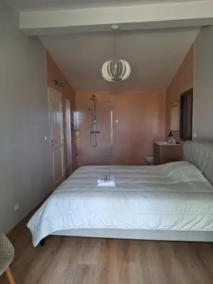 a bedroom with a large white bed in a room at Chambre indépendante dans jardin calme avec vue mer Skhirat in Skhirat