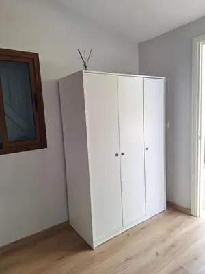 a white cabinet in the corner of a room at Chambre indépendante dans jardin calme avec vue mer Skhirat in Skhirat