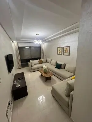 a living room with a couch and a table at Palm Pool View Apartment - Bouznika in Bouznika
