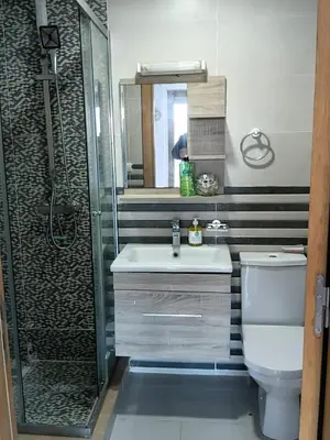 a bathroom with a shower and a sink and a toilet at Palm Pool View Apartment - Bouznika in Bouznika
