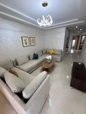 a living room with a couch and a table at Palm Pool View Apartment - Bouznika in Bouznika