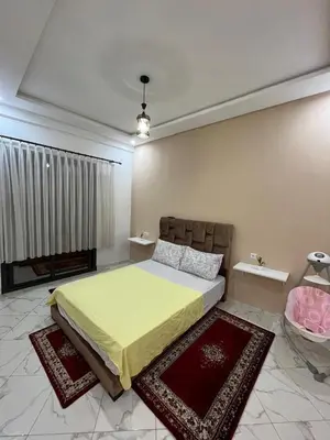 a bedroom with a bed and two rugs at Charming appartement next to the airport in Deroua