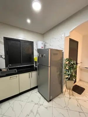 a kitchen with a stainless steel refrigerator and a plant at Charming appartement next to the airport in Deroua