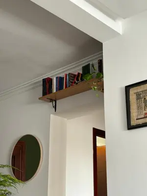 a shelf on a wall with books on it at The Green homestay in Rabat