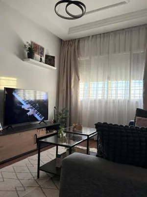 a living room with a tv and a couch and a table at The Green homestay in Rabat