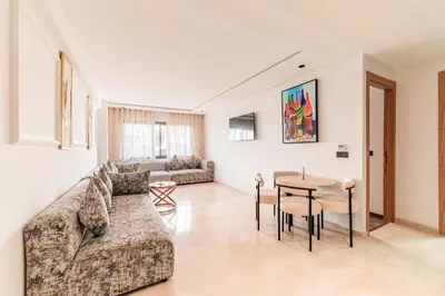 a living room with a couch and a table at L'osmo - 1 BR - 2m from CFC in Casablanca