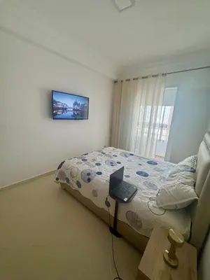 a bedroom with a bed and a laptop on a table at Appartement lumineux a belvedere in Casablanca