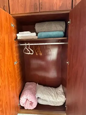 a wooden cabinet with towels and a bed in it at Casablanca ANFA Apartment in Casablanca