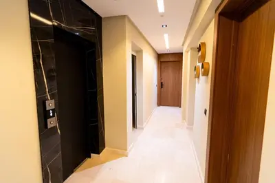 a hallway with a black door and a tile floor at Suite Cosy Moderne Chic Calme Jardin and Habous in Casablanca