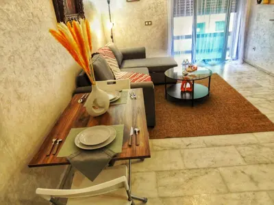 a living room with a couch and a table at Appart de luxe, Confort et Emplacement, Corniche STAY MEMORIES in Mohammedia