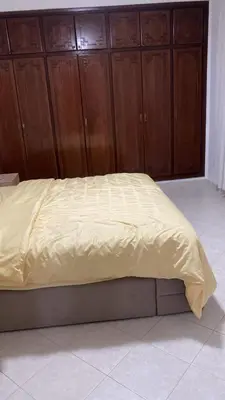 a bed in a bedroom with wooden cabinets at Big Villa In Rabat in Rabat