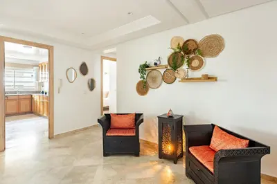 a living room with two chairs and a fireplace at Spacious, 2 BDR, Balcony, AC, Parking, Fiber Optic - Agdal in Rabat