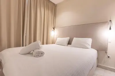 a bedroom with a white bed with a stuffed animal on it at B-living Luxury studio Maarif palmier in Casablanca