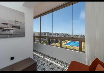 a room with a large window with a view of a pool at Appartement Cosy avec Vue Piscine in Mansouria