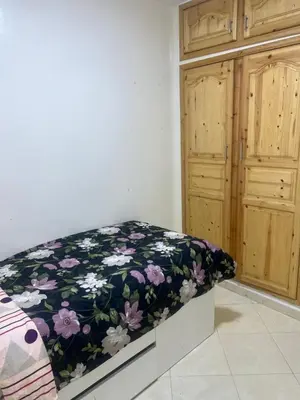 a room with a bench with a floral blanket at Appartement in Mohammedia