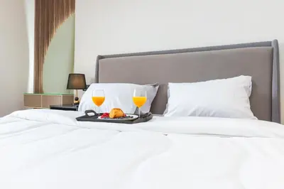 a bed with a tray of food and two glasses of orange juice at Cosy Netflix & Amazing Sunset View in Casablanca