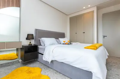 a bedroom with a large white bed and a yellow rug at Cosy Netflix & Amazing Sunset View in Casablanca