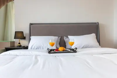 a tray of orange juice and two glasses on a bed at Cosy Netflix & Amazing Sunset View in Casablanca