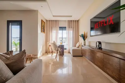 a living room with a couch and a television at Casablanca Panorama Apartment in Casablanca
