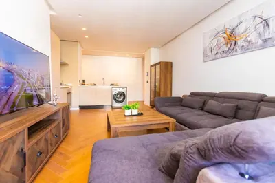 a living room with a couch and a flat screen tv at Cosy Flat for Business Trip at CFC - Infinity Pool in Casablanca