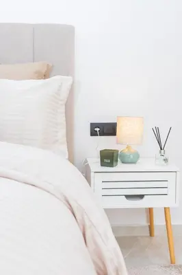 a white bedroom with a bed and a nightstand with a lamp at M Studio cosy princesses in Casablanca