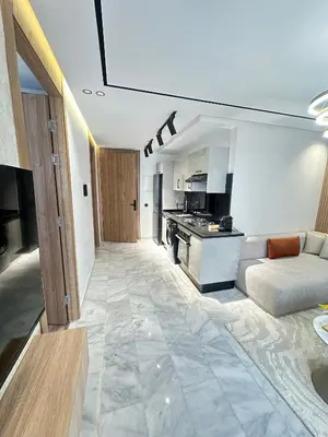 a living room with a couch and a kitchen at France Ville 2 Appartement Meublé Premium avec Terrasse in Maarif