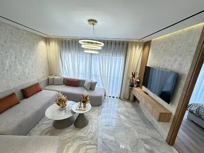 a living room with a couch and a tv at France Ville 2 Appartement Meublé Premium avec Terrasse in Maarif